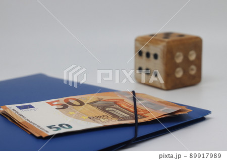 Wooden spmodel cube on the background of banknotes. The concept of the unpredictability Wooden spmodel cube on the background of banknotes. The concept of the unpredictability 89917989