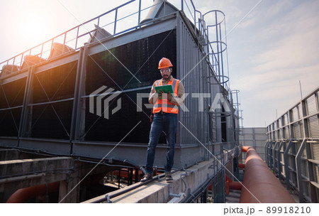 Industry engineer under checking the industry cooling tower air conditioner is water cooling tower air chiller HVAC of large industrial building to control air system. 89918210