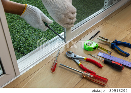 Worker fixing the insect screen sliding door Worker fixing the insect screen sliding door 89918292