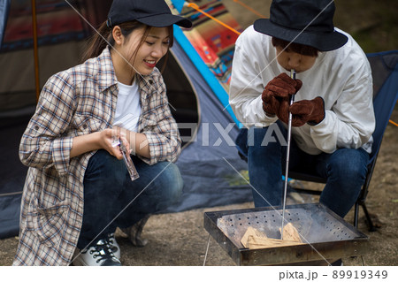 火吹き棒で焚火を起こすカップル 火吹き棒で焚火を起こすカップル 89919349