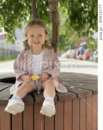 baby girl portrait sitting on the bench in Summer Park 89919777