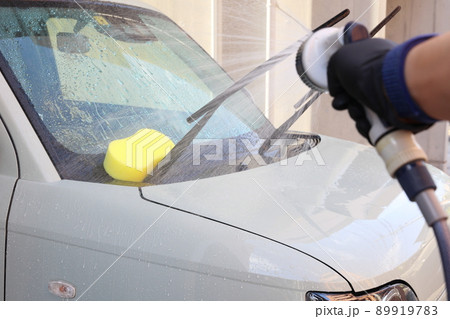 水で小ゴミを流してからシャンプーをする最中の洗車の風景 89919783