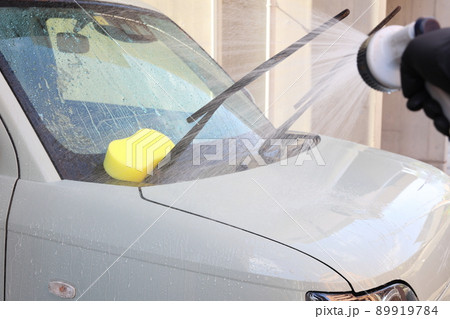 水で小ゴミを流してからシャンプーをする最中の洗車の風景 89919784