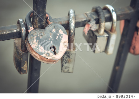 Locks of love on the railing in the city park. Many locks of love hang on a metal fence in a city park 89920147