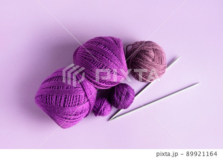 Purple lilac and pink knitted wool on a lilac background for knitting warm clothes and hobbies needlework Purple lilac and pink knitted wool on a lilac background for knitting warm clothes and hobbies needlework 89921164