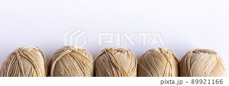Beige yarn threads on a white background for knitting. Flat lay Beige yarn threads on a white background for knitting. Flat lay 89921166