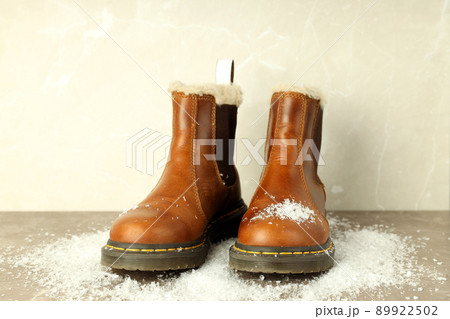 Boots with snow on gray textured table Boots with snow on gray textured table 89922502