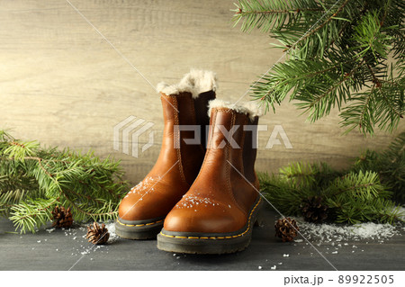 Concept of winter clothes with boots on dark wooden table Concept of winter clothes with boots on dark wooden table 89922505