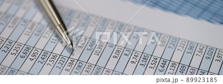 Metal pen lying on documents with graphs closeup Metal pen lying on documents with graphs closeup 89923185