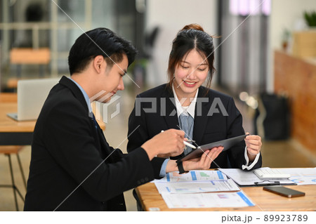Shot of business partner discussing project strategy while having conversation on financial data report together at office Shot of business partner discussing project strategy while having conversation on financial data report together at office 89923789