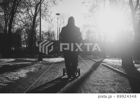 Grandfather walking with a baby stroller on snowy winter day 89924348