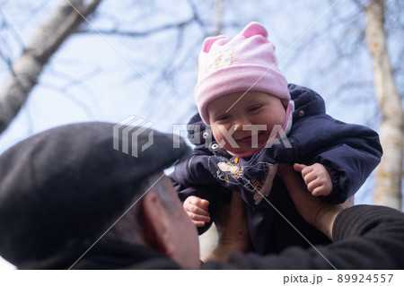 Grandfather walking with a baby playing spending time together lifting baby up Grandfather walking with a baby playing spending time together lifting baby up 89924557