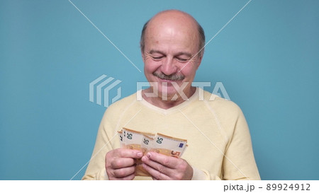 Male pensioner counting money isolated on white background 89924912