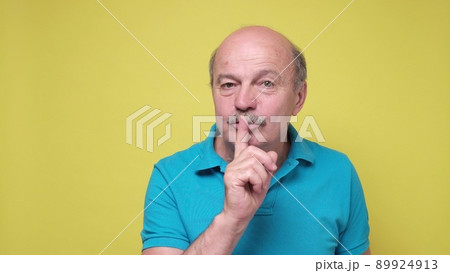 Senior man showing shh gesture, asking for silence or to be quiet. 89924913
