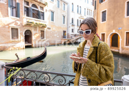 Woman with phone traveling in Venice 89925026