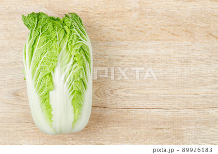 Fresh napa cabbage on white background on wooden background. Fresh napa cabbage on white background on wooden background. 89926183