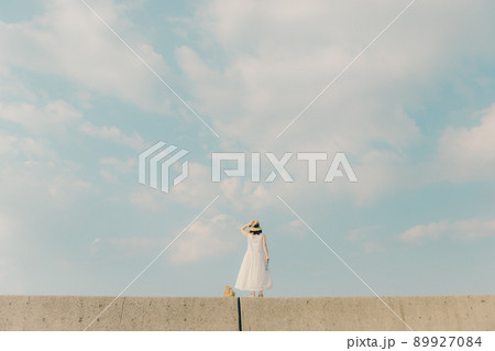 ワンピース姿の女性と綺麗な夏の空 89927084