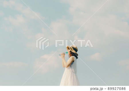 ワンピース姿の女性と綺麗な夏の空 89927086