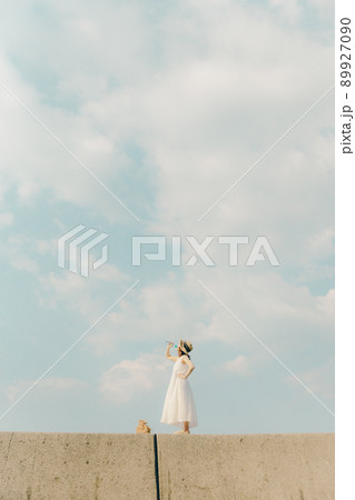 ワンピース姿の女性と綺麗な夏の空 89927090