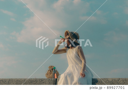 ワンピース姿の女性と綺麗な夏の空 89927701