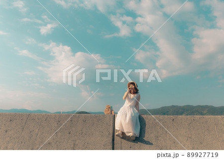 ワンピース姿の女性と綺麗な夏の空 89927719