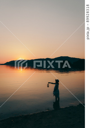 ワンピース姿の女性のシルエットと綺麗な夏の美しい夕焼け空 ワンピース姿の女性のシルエットと綺麗な夏の美しい夕焼け空 89928318