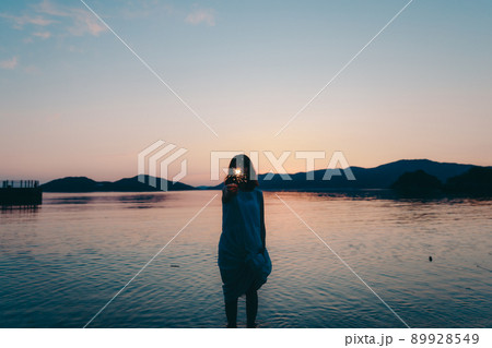 ワンピース姿の女性のシルエットと綺麗な夏の美しい夕焼け ワンピース姿の女性のシルエットと綺麗な夏の美しい夕焼け 89928549