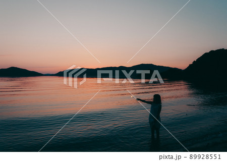 ワンピース姿の女性のシルエットと綺麗な夏の美しい夕焼け ワンピース姿の女性のシルエットと綺麗な夏の美しい夕焼け 89928551