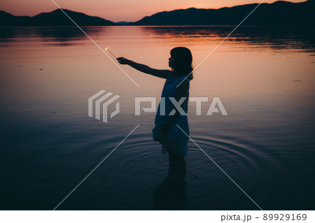 ワンピース姿の女性のシルエットと綺麗な夏の美しい夕焼け ワンピース姿の女性のシルエットと綺麗な夏の美しい夕焼け 89929169
