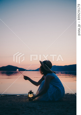 ワンピース姿の女性のシルエットと綺麗な夏の美しい夕焼け ワンピース姿の女性のシルエットと綺麗な夏の美しい夕焼け 89929179