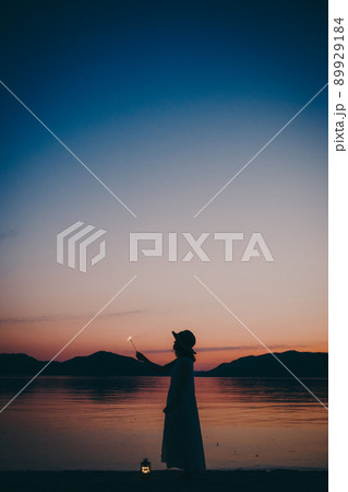 ワンピース姿の女性のシルエットと綺麗な夏の美しい夕焼け ワンピース姿の女性のシルエットと綺麗な夏の美しい夕焼け 89929184
