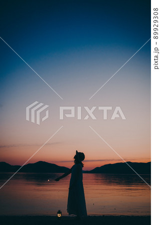 ワンピース姿の女性のシルエットと綺麗な夏の美しい夕焼け ワンピース姿の女性のシルエットと綺麗な夏の美しい夕焼け 89929308