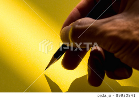 Human's hand holding pencil to write on the paper in shadow Human's hand holding pencil to write on the paper in shadow 89930841