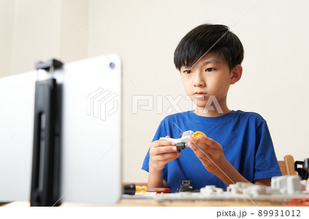 タブレットを見ながら模型を組み立てる小学生の男の子 タブレットを見ながら模型を組み立てる小学生の男の子 89931012