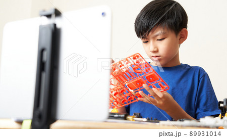 プラモデルを組み立てる小学生の男の子 89931014