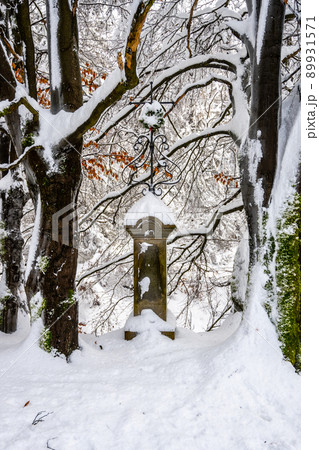Old Christian memorial in winter forest 89931571