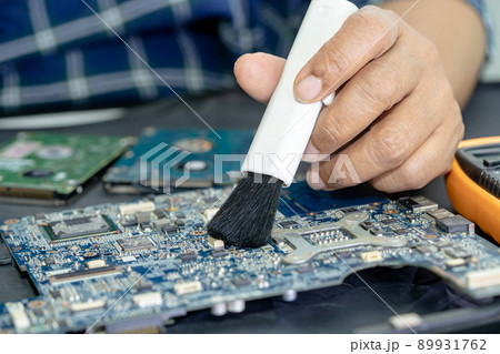 Technician use brush and air blower ball to clean dust in circuit board computer. Repair upgrade and maintenance technology. Technician use brush and air blower ball to clean dust in circuit board computer. Repair upgrade and maintenance technology. 89931762