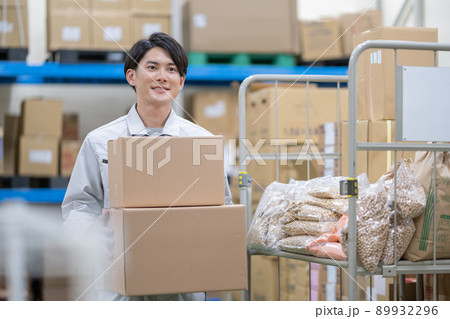 物流センターで荷物を運ぶ若い男性 物流センターで荷物を運ぶ若い男性 89932296