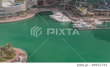 Waterfront promenade with palms in Dubai Marina aerial timelapse. 89932743