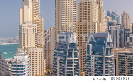 Modern skyscrapers in Dubai Marina, close up view to many windows aerial timelapse. 89932918
