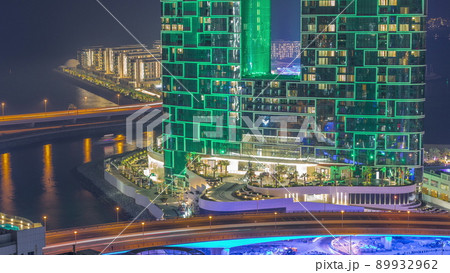 Promenade and bridge traffic seen from Dubai marina night timelapse. Aerial view to JBR district and Bluewaters Island behind Promenade and bridge traffic seen from Dubai marina night timelapse. Aerial view to JBR district and Bluewaters Island behind 89932962