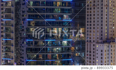 Windows of apartment buildings at night timelapse, the light from the windows of houses 89933375