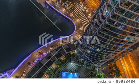 Dubai marina promenade on waterfront along canal aerial night timelapse. 89933484