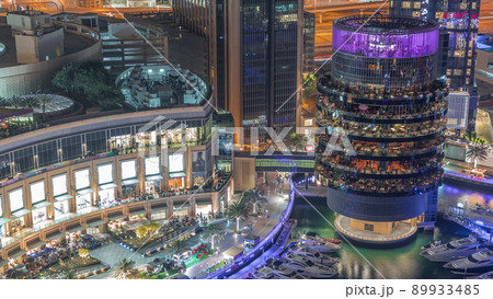 Dubai marina waterfront and building with different restaurants at each floor aerial night timelapse. 89933485