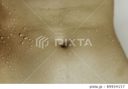 Close-up image of female beautiful slim belly with water drops. 89934157