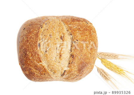 Loaf of round bread with wheat ears isolated on white background. 89935326