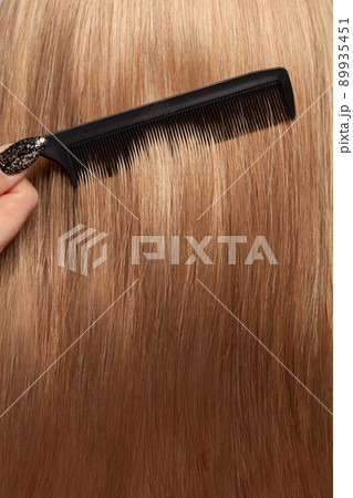 Beautiful straight smooth long hair and black comb, hair care concept Beautiful straight smooth long hair and black comb, hair care concept 89935451