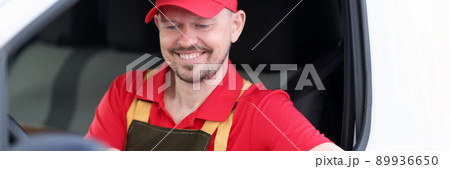 Male courier sitting in the car looking at the delivery address Male courier sitting in the car looking at the delivery address 89936650