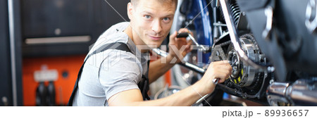 Male mechanic in a garage repairing a motorcycle 89936657