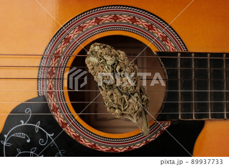 Music and marijuana concept.. Dry cannabis bud lays on the guitar 89937733